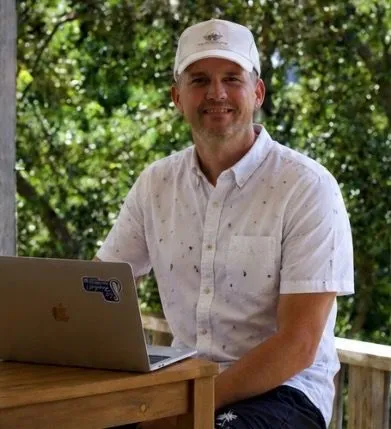 Joshua working at a laptop outdoors